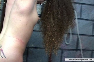 curly-haired babe enjoys bondaged